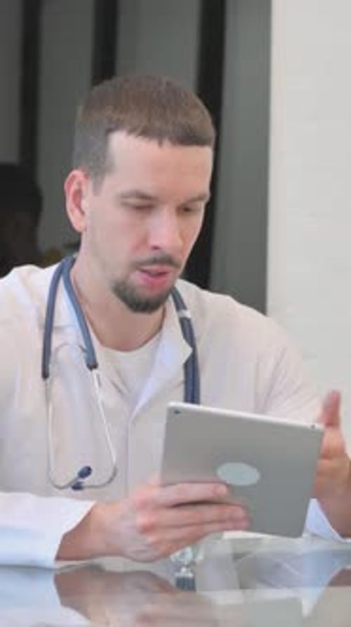 Concerned Doctor Consults Tablet in Clinic