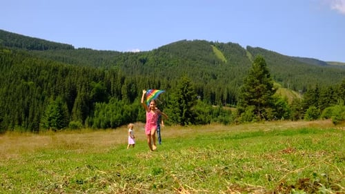 Girl Running with Kite in Green Mountain Field
