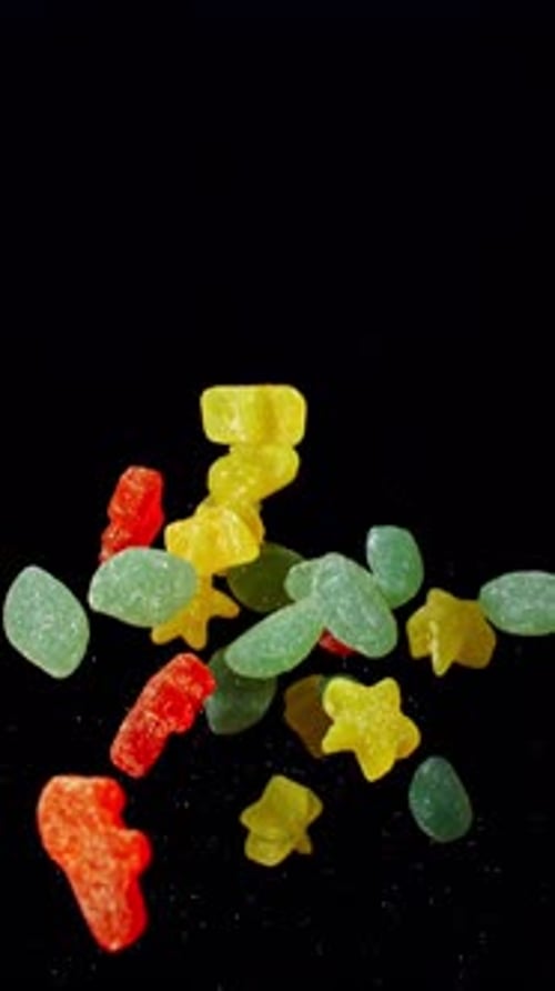 Colourful Gummies Falling in Front of Black Backdrop
