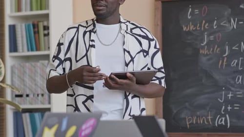 Adult Teacher Presents Information with Tablet