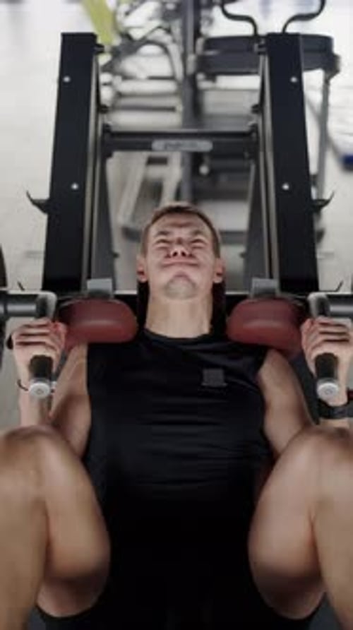 Dedicated Young Man Exercising on a Gym Bench Press