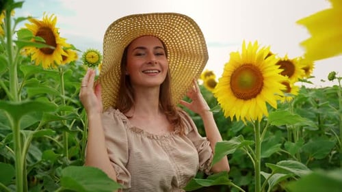 Beautiful Young Girl Enjoying Nature on the Field of Sunflowers at Sunset