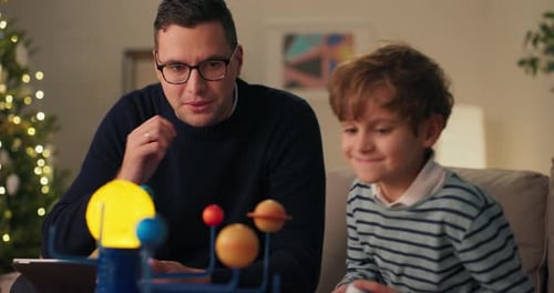 Father and Son Building Solar System Model at Home