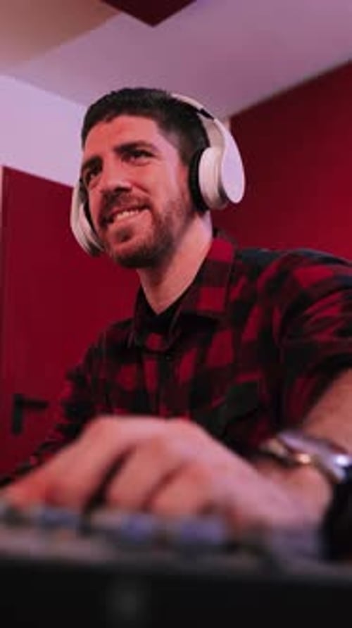 Vertical Individual Close Up Portrait of a Young Man Equalizing Song in a Professional Music Studio