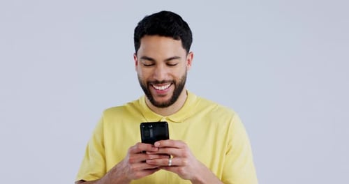 Man, laugh and typing with phone in studio, scroll social media and reading funny notification