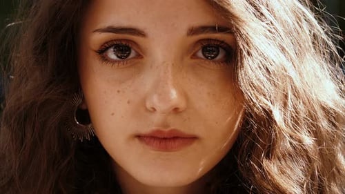 youth, beauty - close up on beautiful girl's face stares serious at camera