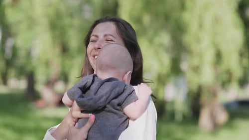 Mother Cradling Baby in the Park
