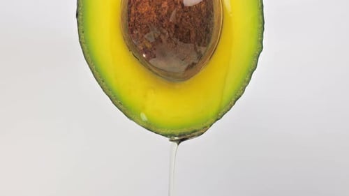 Bright Avocado Half Drips Water