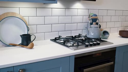 White and Blue kitchen with white ceramic tiled splash-back, blue cabinets and cooker and oven.
