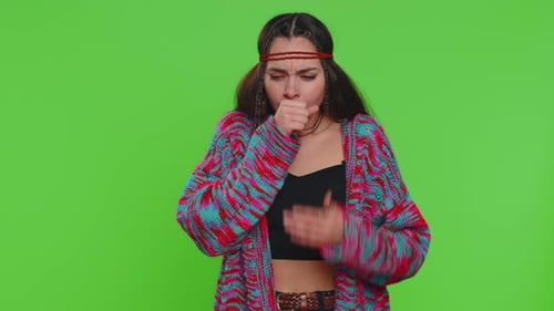 Young Adult Woman Coughing Against a Green Background