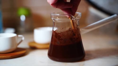 Kochender türkischer Kaffee, Nahaufnahme, moderner Look. Prozess der Kaffeezubereitung zu Hause. Frau macht Kaffee