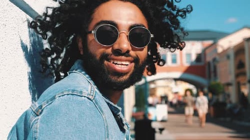 Man Smiling with Sunglasses by a Building
