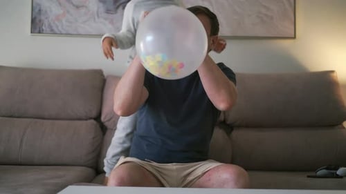 Dad and Daughter Blow Up Birthday Balloon