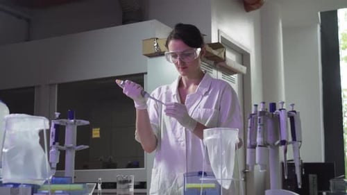 Woman Scientist Measuring Fluid in a Lab
