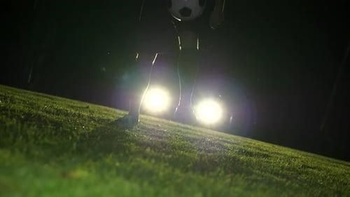 Soccer Player Juggling Ball at Night