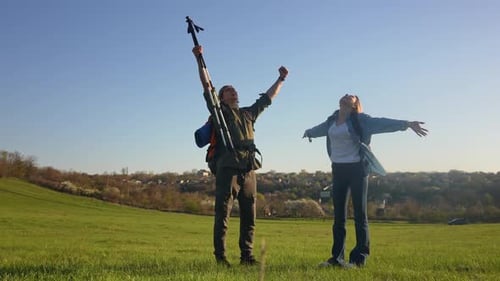 Couple Celebrates Hiking Achievement in Green Field
