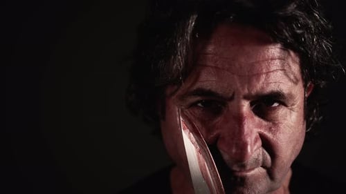Intense Man Holds Bloody Knife Close Up