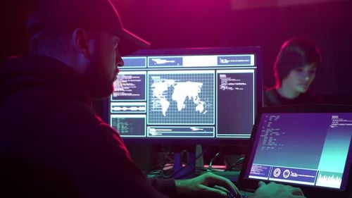 Two Adults Working on Computers in a Dark Room
