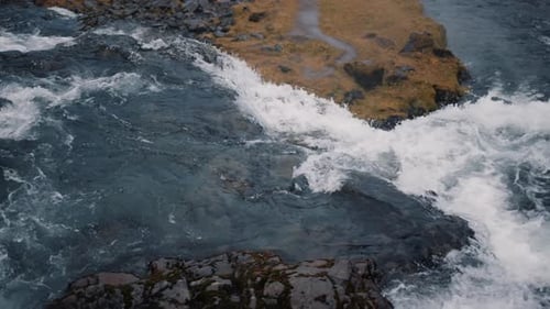Fluss, der an dunklen, klaren Tagen zwischen Felsen und Hügeln fließt