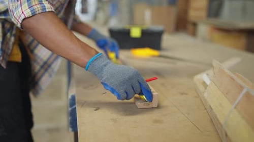 Close up African American carpenter or woodworker or charpentier man use measuring tape to measure