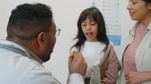 Doctor Examining Young Girl in Medical Office