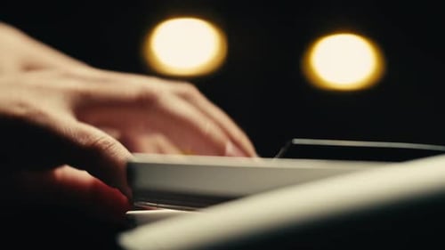 Hands Playing Electric Piano at Night