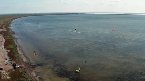 People go kitesurfing on the sea. The wind carries the athlete along the sea waves