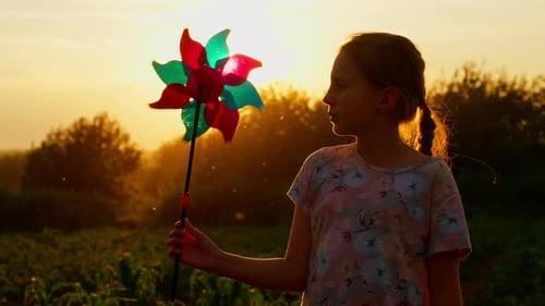 Silhouette of Child Girl Holding Wind Toy