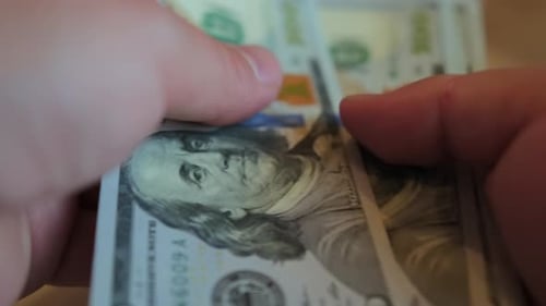Close up hands counting US Dollar bills or paying in cash. Concept of investment
