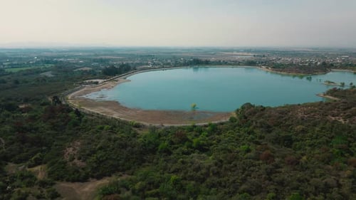 Aerial drone flying over a blue water lake with mountains landscape
