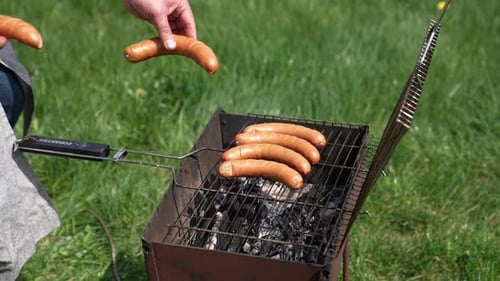 Sausages roasting on barbecue grill outdoors. Grilled food fried and smoked in charcoal grills.