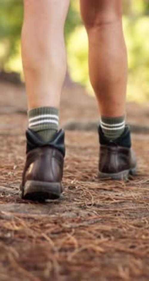 Back, hiking and man with feet, walking and fitness in forest, environment and hobby with boots