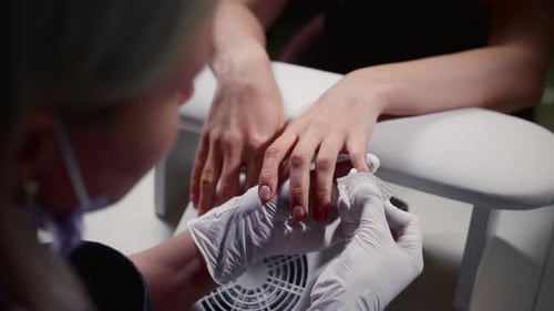 Manicurist in Gloves Wipes Nails with Special Liquid Manicure Master Wipes the Nails with a Napkin