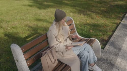30Yearold Blonde Reading on Park Bench with Amazed Expression