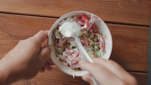 Male Hands Add Sour Cream to the Salad and Stir with a Spoon
