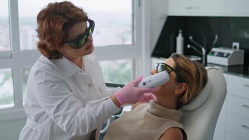 Woman Lying On Rejuvenation Laser Procedure At Modern Cosmetology Clinic Close Up. Professional B...