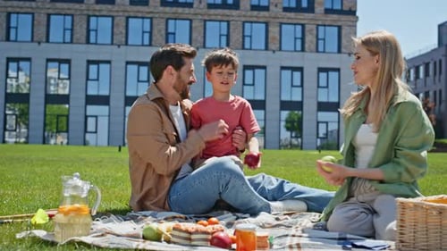 Family Picnic Together in Urban Park on Sunny Day