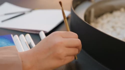 Serene Painter Arranges Brushes with Care and Precision Tranquil Art Space Sees Artist Thoughtfully