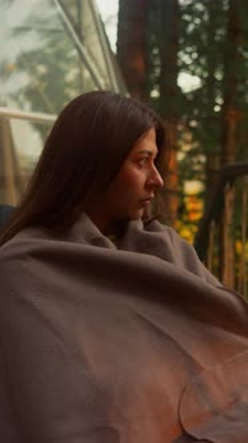 Woman Covers with Blanket on Terrace of Glamping House