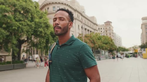 Young man tourist walks along the square of the old city, considers the sights