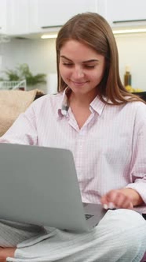 Woman Working on Laptop in Kitchen at Home