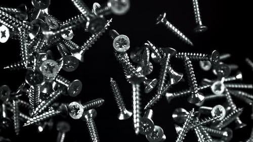 Falling Metal Screws on Black Background