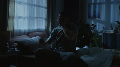 Restless Man Wakes Up in Dark Bedroom