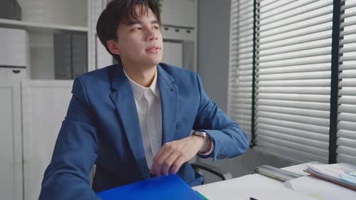 Asian businessman turning off laptop computer after working in office.