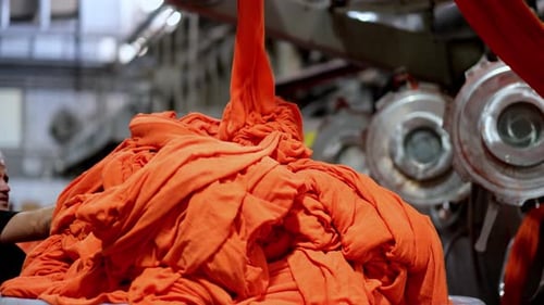 Worker Handling Industrial Laundry in Factory Setting