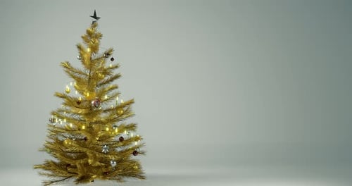 Sapin de Noël doré tournant autour de lui-même sur fond blanc