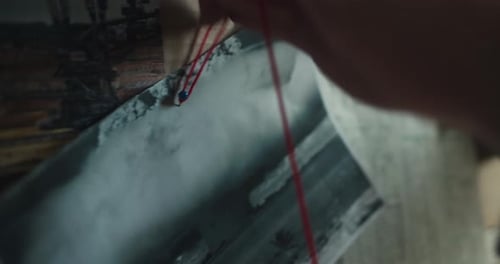 Hands Connecting the Dots on a Crime Board