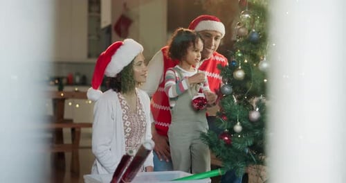 Happy Family Decorates Christmas Tree in Home