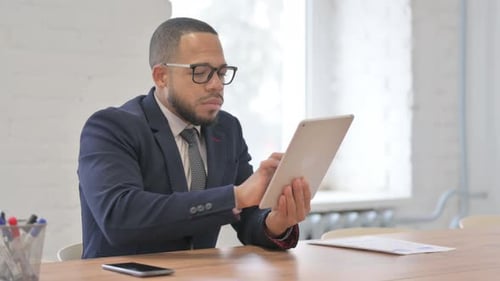 Adult Man Works on Tablet at Desk