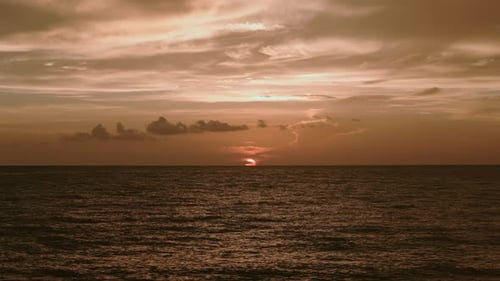 Ocean Beach Sunsets Burning Gold Colorful Sky and Shining Waves Aerial Drone Wide Shot Footage